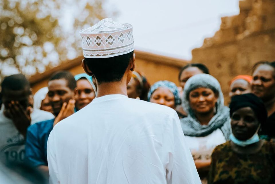 A speaker addressing a smiling community crowd