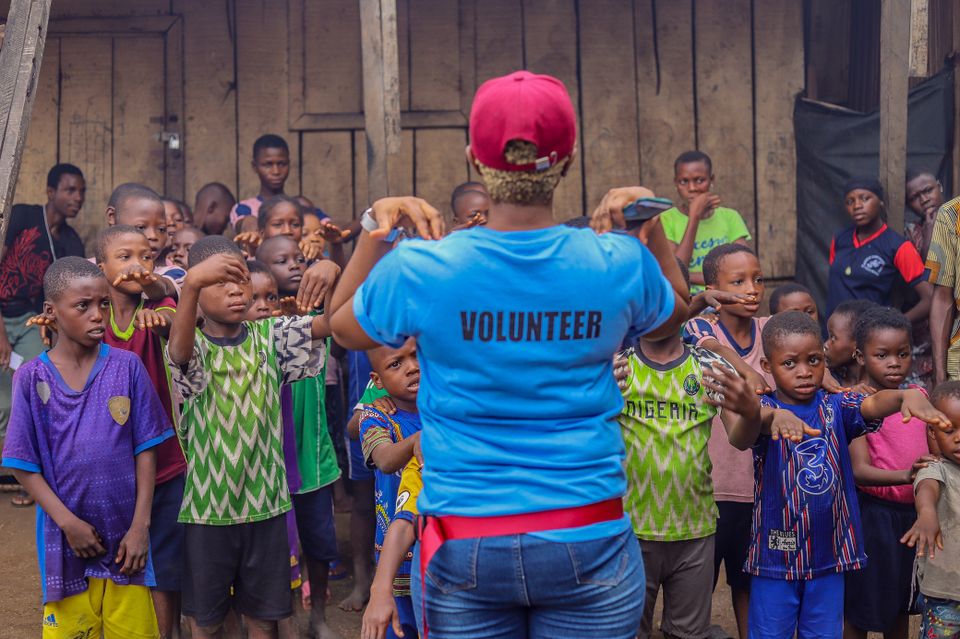 A volunteer leading a group activity with village children